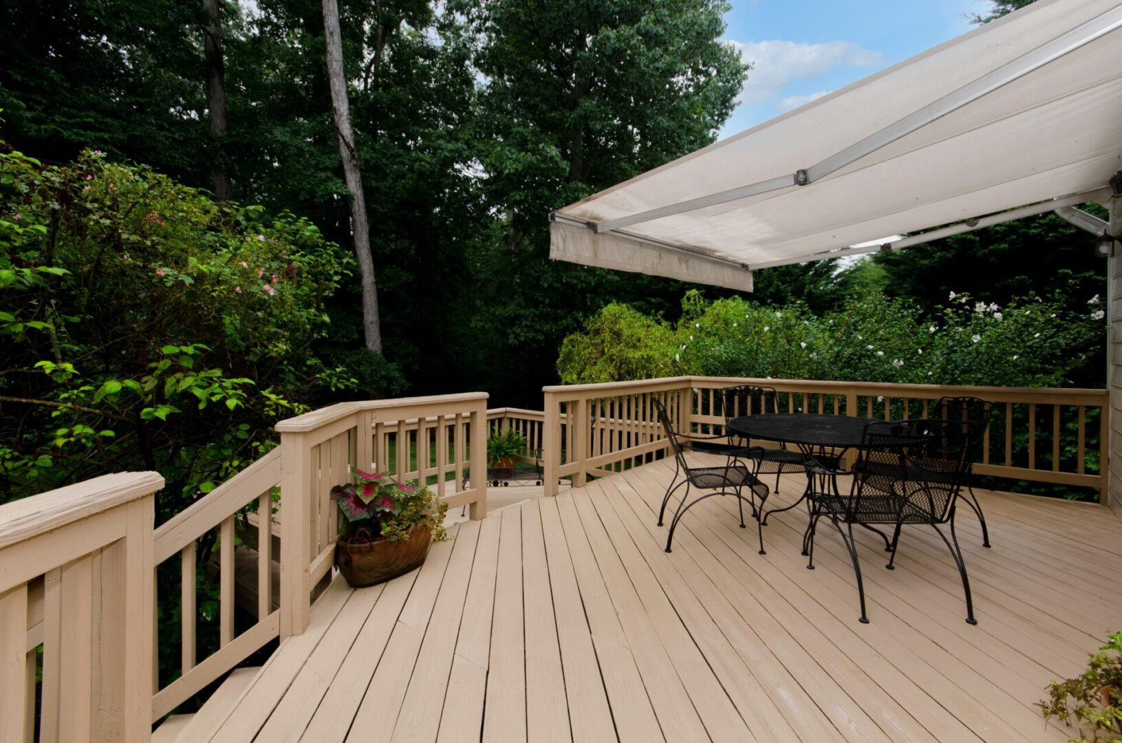 Spacious deck with outdoor seating and awning.