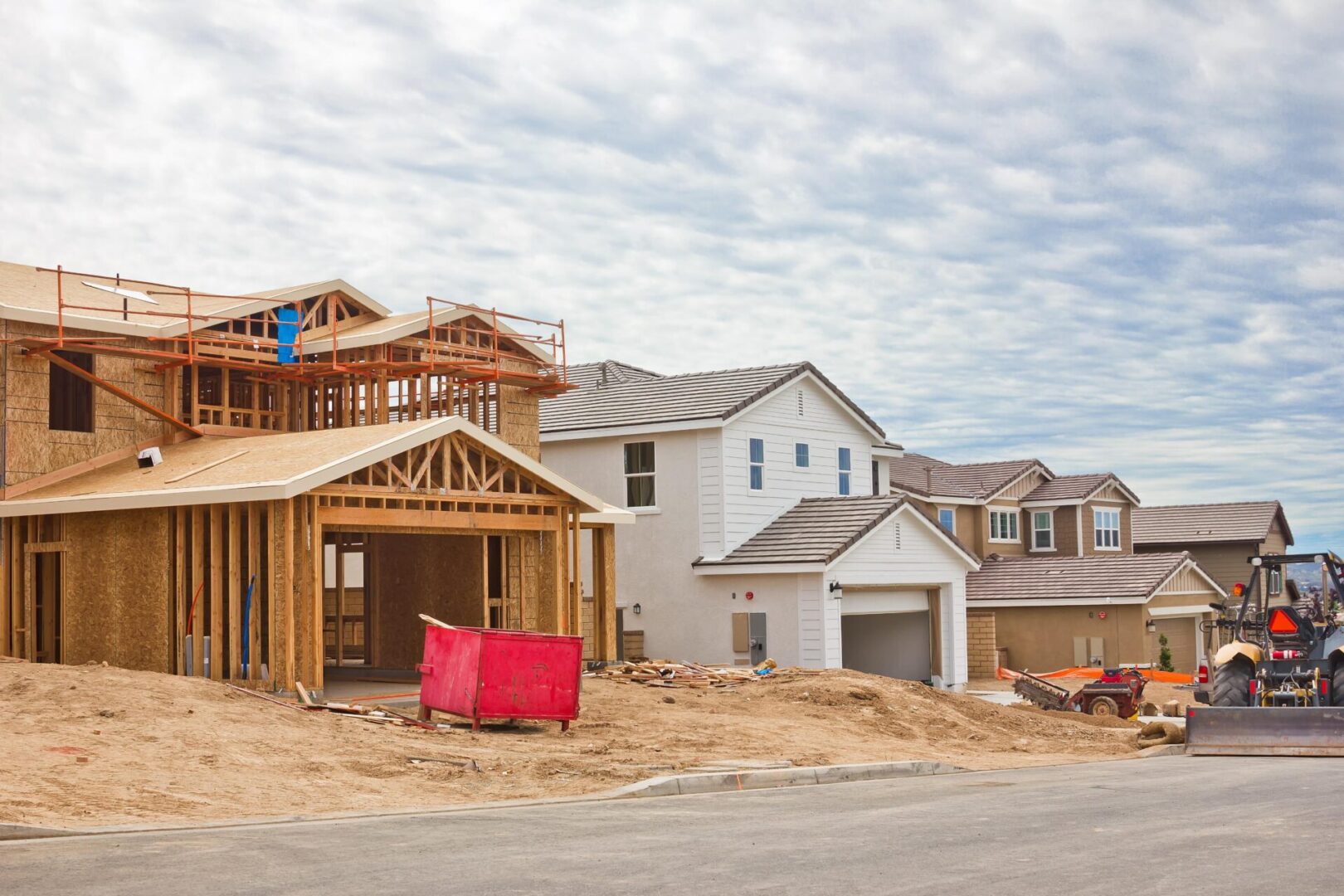 New houses under construction on suburban street.